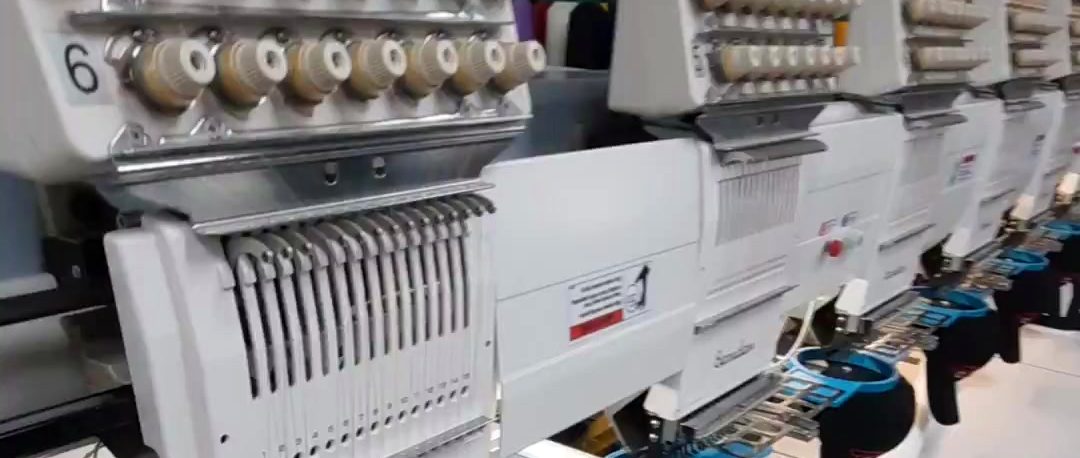 A row of Barudan embroidery heads with black caps on the cap frames in the Newhall shop