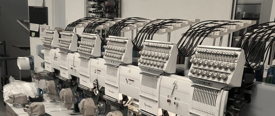 A row of Barudan embroidery heads fitted with cap frames at MMM Embroidery in Newhall