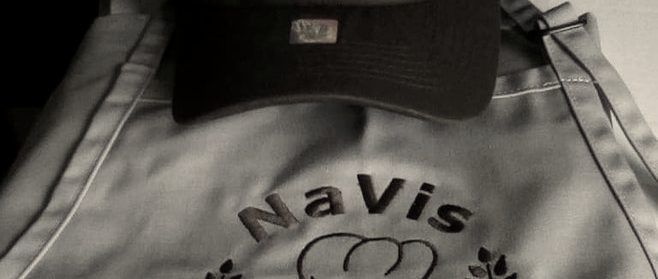 A brown cap and a grey apron, both embroidered with a bakery's chef-hat logo