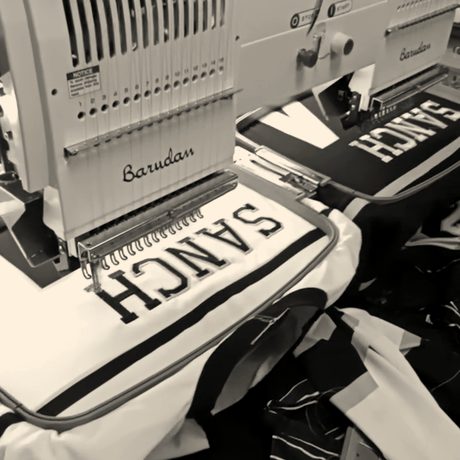 Name plates being stitched on baseball jerseys