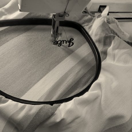 A striped beach towel in the hoop with a name stitched in script