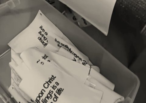 Printed canvas banners stacked in a bin after the dryer