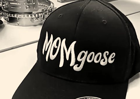A black cap with a word in white script across the front
