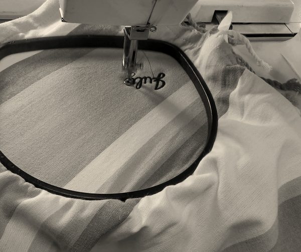 A name being stitched on a beach towel