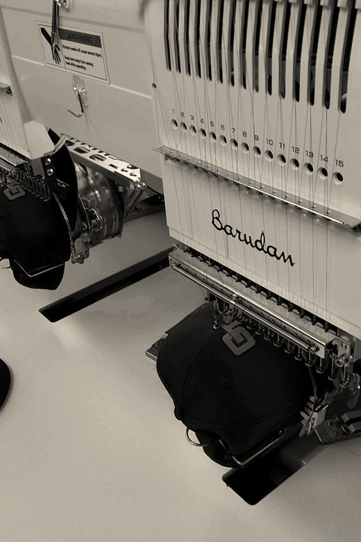 A Barudan embroidery head with a black cap on the cap frame