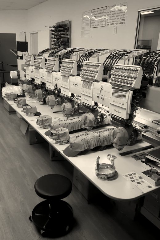 A row of Barudan multi-head machines with tan caps on the cap frames