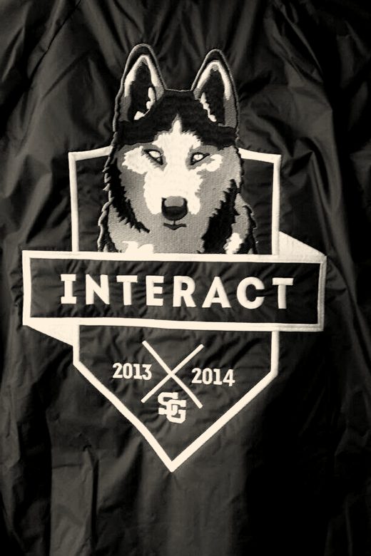 The back of a black jacket embroidered with a wolf head over a club shield