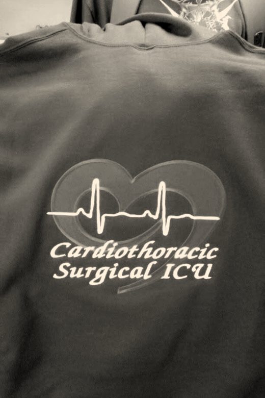 A finished jacket back with a red heart, a heartbeat line and a hospital unit name in white script