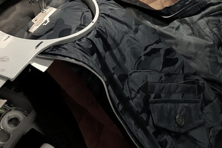 Navy jackets hooped across a multi-head embroidery machine