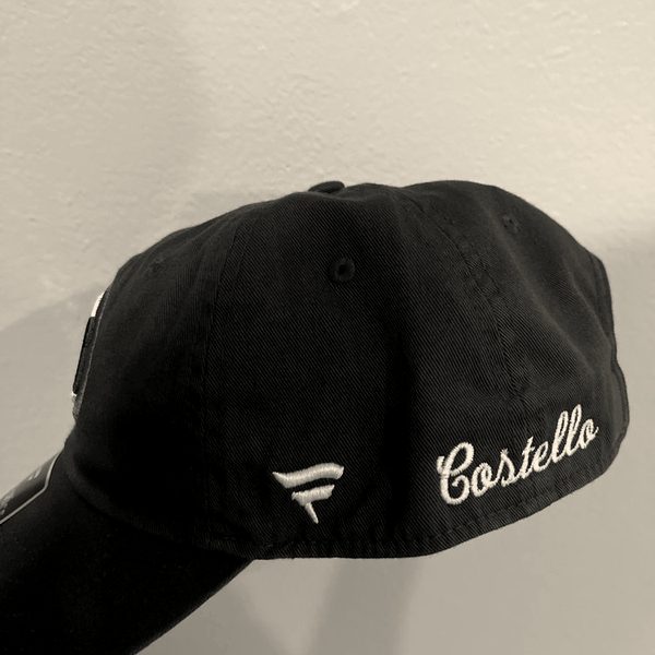 The side of a royal blue cap with a name embroidered in white script